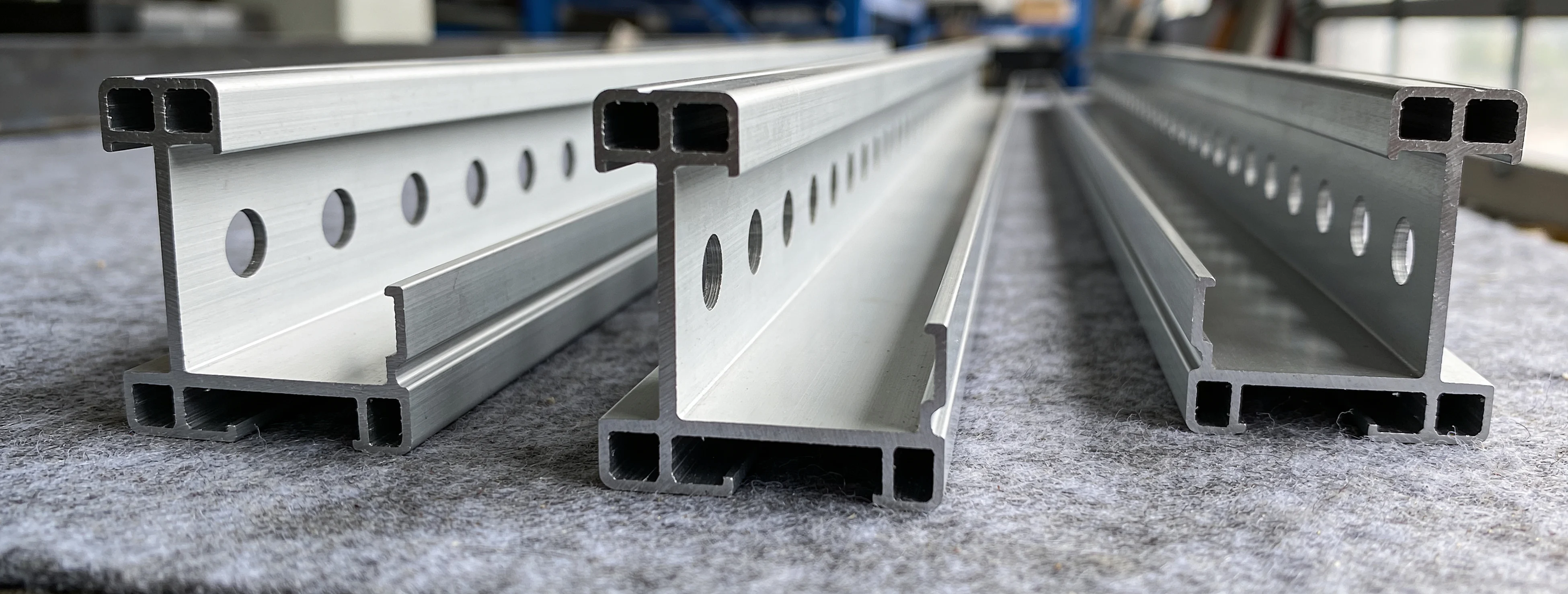 Aluminiumprofile mit Erleichterungslöchern auf grauem Filz